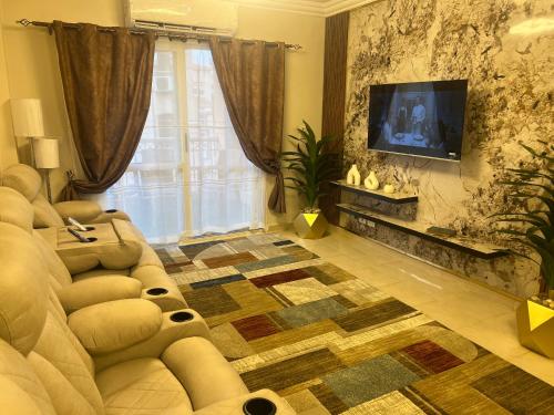 a living room with a couch and a flat screen tv at Luxurious VIP Apartment in Madinaty Furnished with High End Hotel Furniture in Madinaty