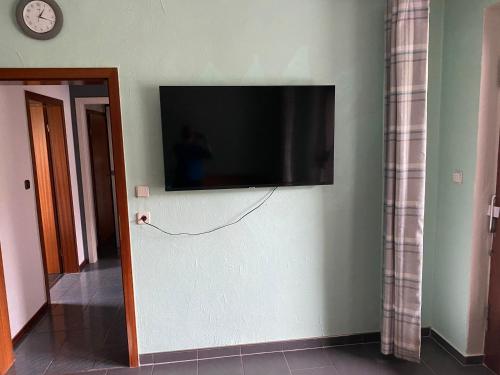 einen Flachbild-TV an der Wand in einem Zimmer in der Unterkunft Apartment mit romantischem Garten an der Märchenstraße! in Reinhardshagen