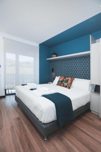 a bedroom with a large bed with a blue wall at Alma Candida 23 in Azenhas