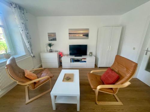 ein Wohnzimmer mit 2 Stühlen und einem Couchtisch in der Unterkunft gemütliches Appartement - 20 min bis Dresden in Leppersdorf