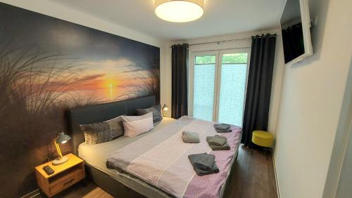 a bedroom with a bed with a painting on the wall at Ferienwohnung Ostsee Graal-Müritz Küstenwald in Gelbensande