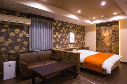 une chambre d'hôtel avec un lit et un canapé dans l'établissement ホテルあかり, à Numazu