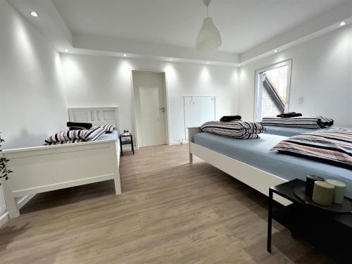 Habitación con 2 camas, paredes blancas y suelo de madera. en GL-Oberkülheim, en Bergisch Gladbach