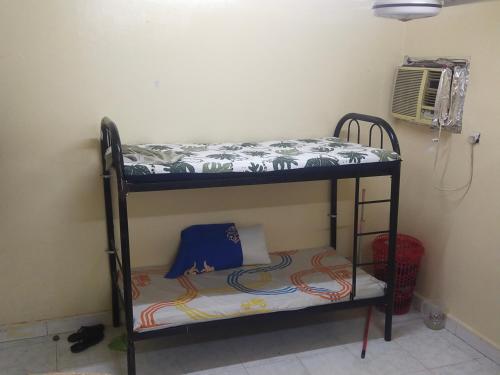a bunk bed in the corner of a room at Bed space abu shagara park in Sharjah