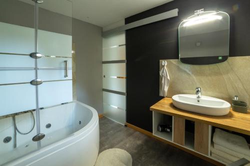 La salle de bains est pourvue d'une baignoire blanche et d'un lavabo. dans l'établissement Apartments Silva, à Ljutomer