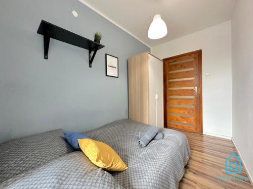 a bedroom with a bed with yellow and blue pillows at World Room in Gdańsk