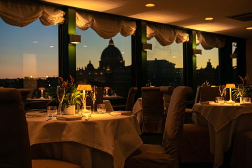 a restaurant with two tables and a view of the city at Atlante Star Hotel in Rome