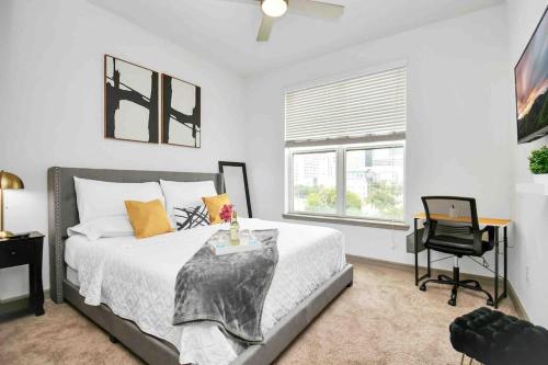 a bedroom with a bed and a desk and a window at HTown Downtown Oasis in Houston