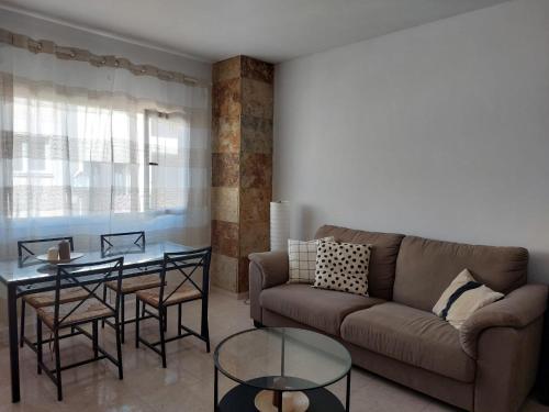 een woonkamer met een bank en een tafel bij Mi isla bonita in Arrecife