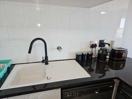 a kitchen counter with a sink in a kitchen at Sea Breeze in Bloubergstrand
