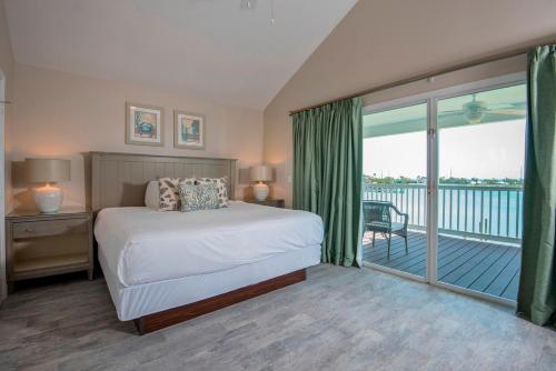 a bedroom with a bed and a balcony at Villas at Hawks Cay Resort in Duck Key