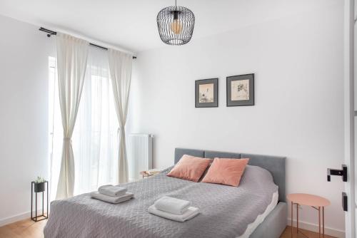 a white bedroom with a bed with two towels on it at Spacious and modern Apartment Lwowska, close to Kazimierz in Krakow