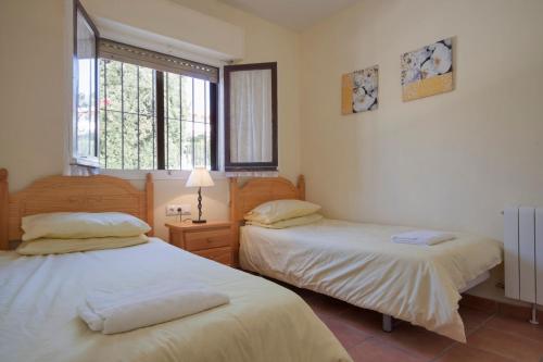 a bedroom with two beds and a window at Villa Carmen - Plusholidays in Calpe