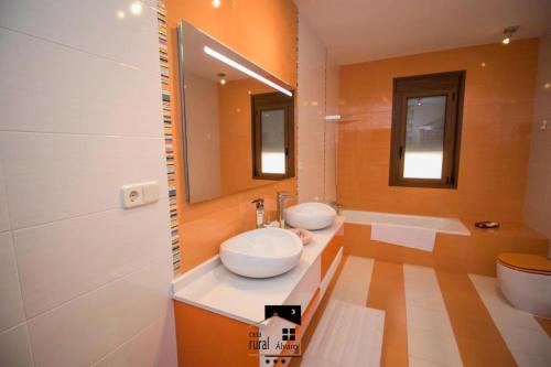 a bathroom with two sinks and a large mirror at Casa Rural Alvaro in Albares