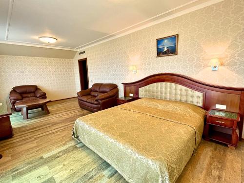 um quarto de hotel com uma cama e duas cadeiras em Aqua View SPA Boutique Hotel em Golden Sands