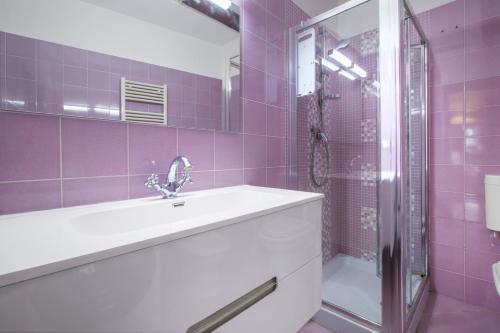 baño púrpura con lavabo y ducha en Brunelleschi View Suite, en Florencia
