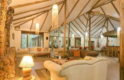 a living room with couches and chairs in a room at Gorilla Safari Lodge in Rubuguli