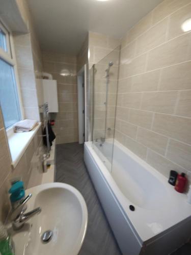 a bathroom with a sink and a shower and a tub at Stylish property near town centre in Tyldesley