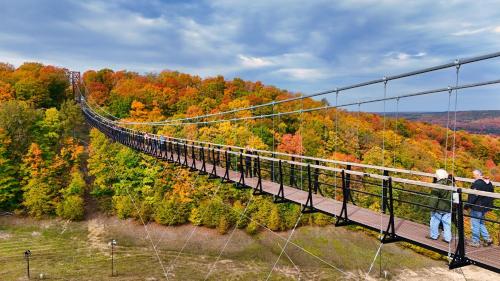 a suspension bridge in the mountains with people on it at 370 Disciples Village Condo in Boyne Falls