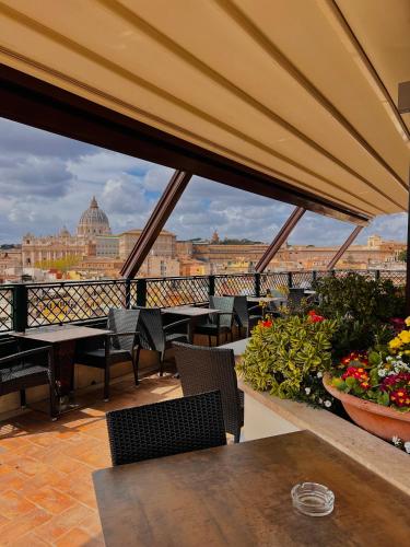 a balcony with tables and chairs and a view of a city at Atlante Star Hotel in Rome