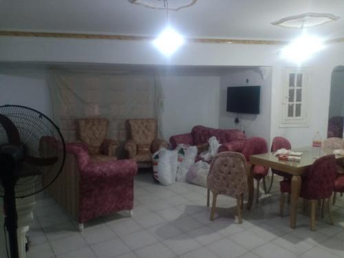 een woonkamer met een bank, stoelen en een tafel bij المريوطية الرئيسي in ‘Ezbet Abu Bakr ‘Allâm