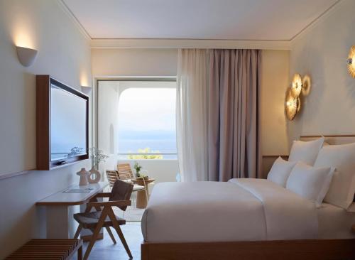Pokój hotelowy z łóżkiem, biurkiem i oknem w obiekcie Brown Beach Chalkida, a member of Brown Hotels w Chalkidzie
