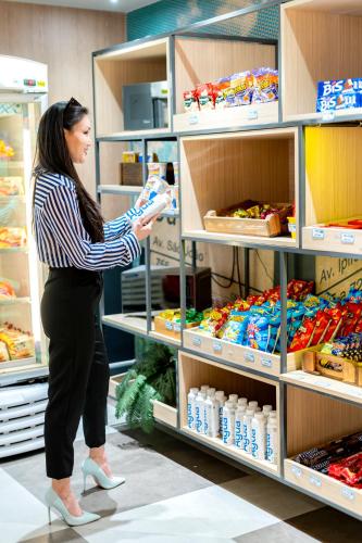 a woman in a store looking for food in a shelf at ibis budget SP Centro Sao Joao in Sao Paulo
