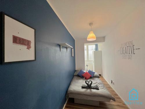 a small room with a bed in a blue wall at Creative room in Gdańsk
