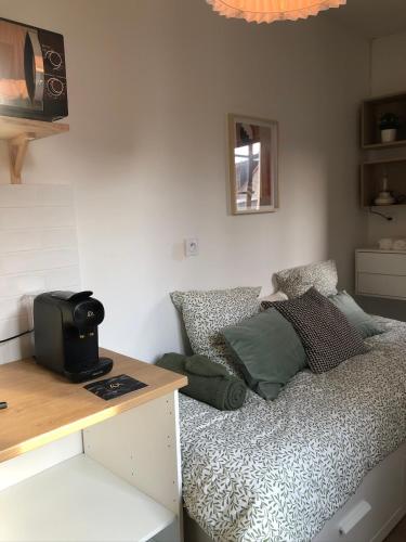 une chambre avec un lit et un bureau avec un micro-ondes dans l'établissement Cocon Urbain - Centre ville - BY PRIMO C0NCIERGERIE, à Chalon-sur-Saône