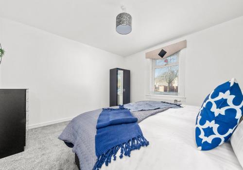 a bedroom with a bed with a blue blanket on it at Back'o'Barns Apartment by Klass Living Hamilton in Hamilton