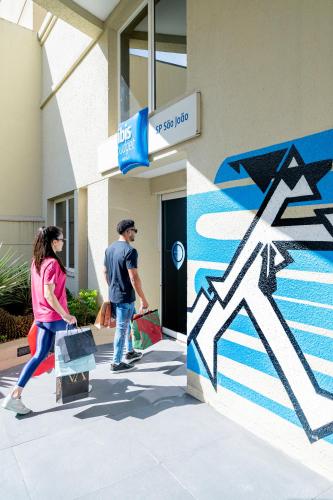 a man and a woman walking outside of a building at ibis budget SP Centro Sao Joao in Sao Paulo