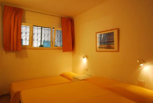 1 dormitorio con 2 camas y 2 ventanas en Appartamenti family & MTB en Finale Ligure