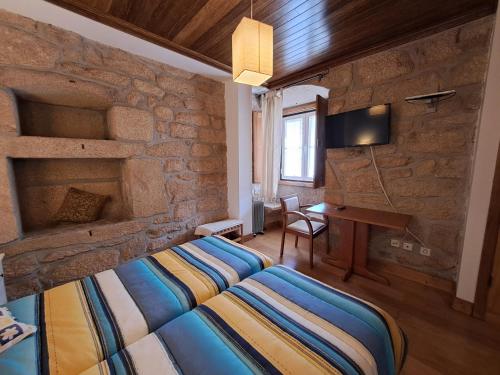 1 dormitorio con cama y pared de piedra en Casa d Toninha - Casas de Campo - Turismo Espaço Rural - AL en Sernancelhe