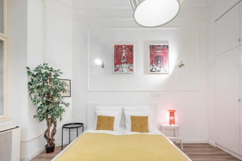 Extra Central Modern Studio في بودابست: غرفة نوم مع سرير وزرع الفخار