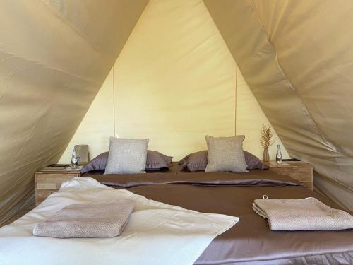 a bedroom with two beds in a tent at Husaak Glamping in AlUla