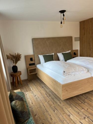 a bedroom with a large bed with a wooden floor at MINAROSO appartements am badeparadies in Titisee-Neustadt