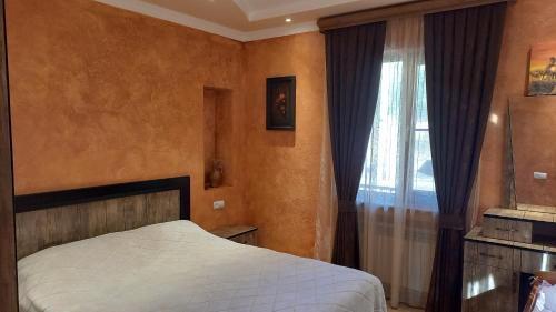 a bedroom with a bed and a window at Cottage Green Garden in Tsaghkadzor