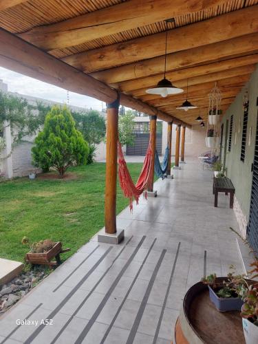 a covered porch with a hammock on a house at Alojamiento Casa Malbec in Mendoza