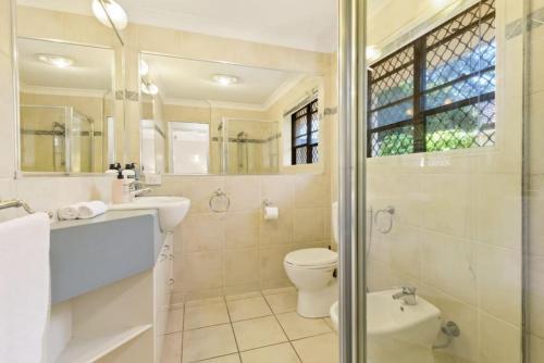 a bathroom with a toilet and a sink and a shower at Decorated with love 4BD Family House with Pool in Brisbane