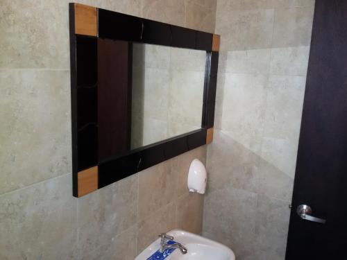 a bathroom with a mirror and a sink at Hotel Las Mercedes Airport-Quito in Tababela