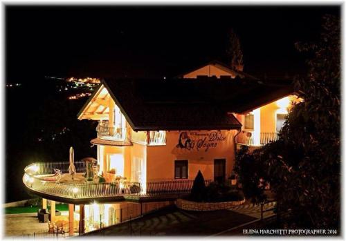 a building with a sign on the side of it at night at Affittacamere Dolce Sogno in Coredo
