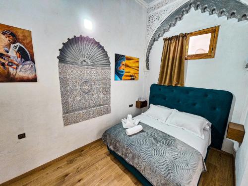 a bedroom with a bed with a blue head board at DAR SABA in Rabat