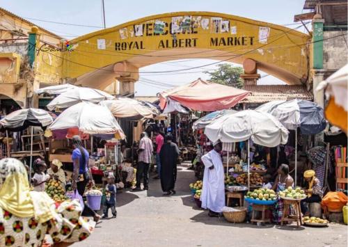 a market with people walking through a market with umbrellas at Seaview Superior Room in Cape Point Bakau - Bojang River Lodge in Bakau