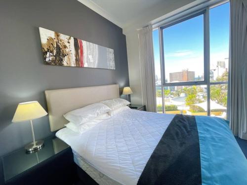 A bed or beds in a room at Prime Location 2BD Serviced Apt at Surfers Paradise