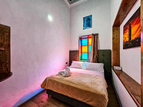 a bedroom with a bed and a stained glass window at DAR SABA in Rabat