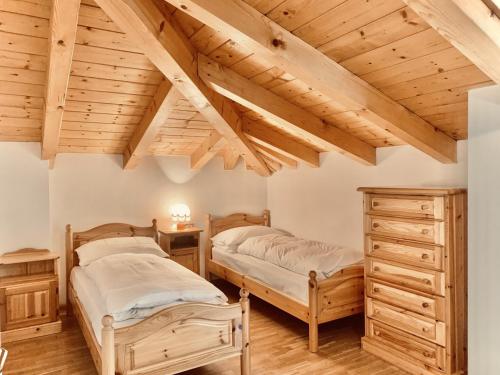 two beds in a room with wooden ceilings at Cesa Cascata in Canazei