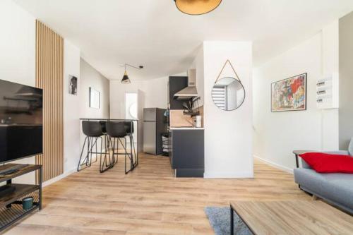 un salon avec un canapé et une cuisine dans l'établissement 3 apparts indépendants Hyper Centre Valenciennes, à Valenciennes