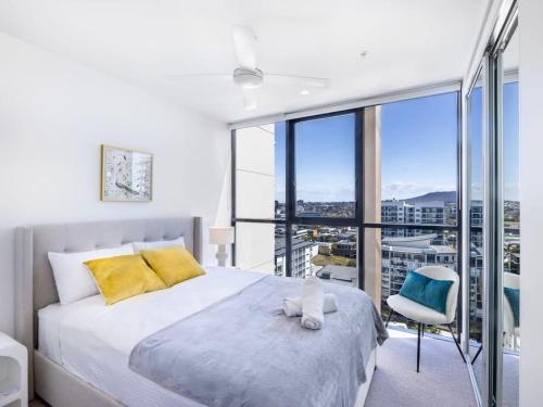 een slaapkamer met een bed en een groot raam bij Conveniently located 2BR apt with rooftop pool at Milt in Brisbane