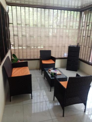 a waiting room with chairs and a table and windows at La Casita in Dos Brazos