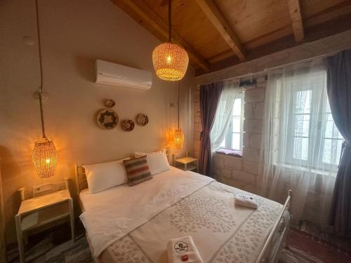 a bedroom with a white bed and a window at Hera Hotels Alaçatı in Cesme